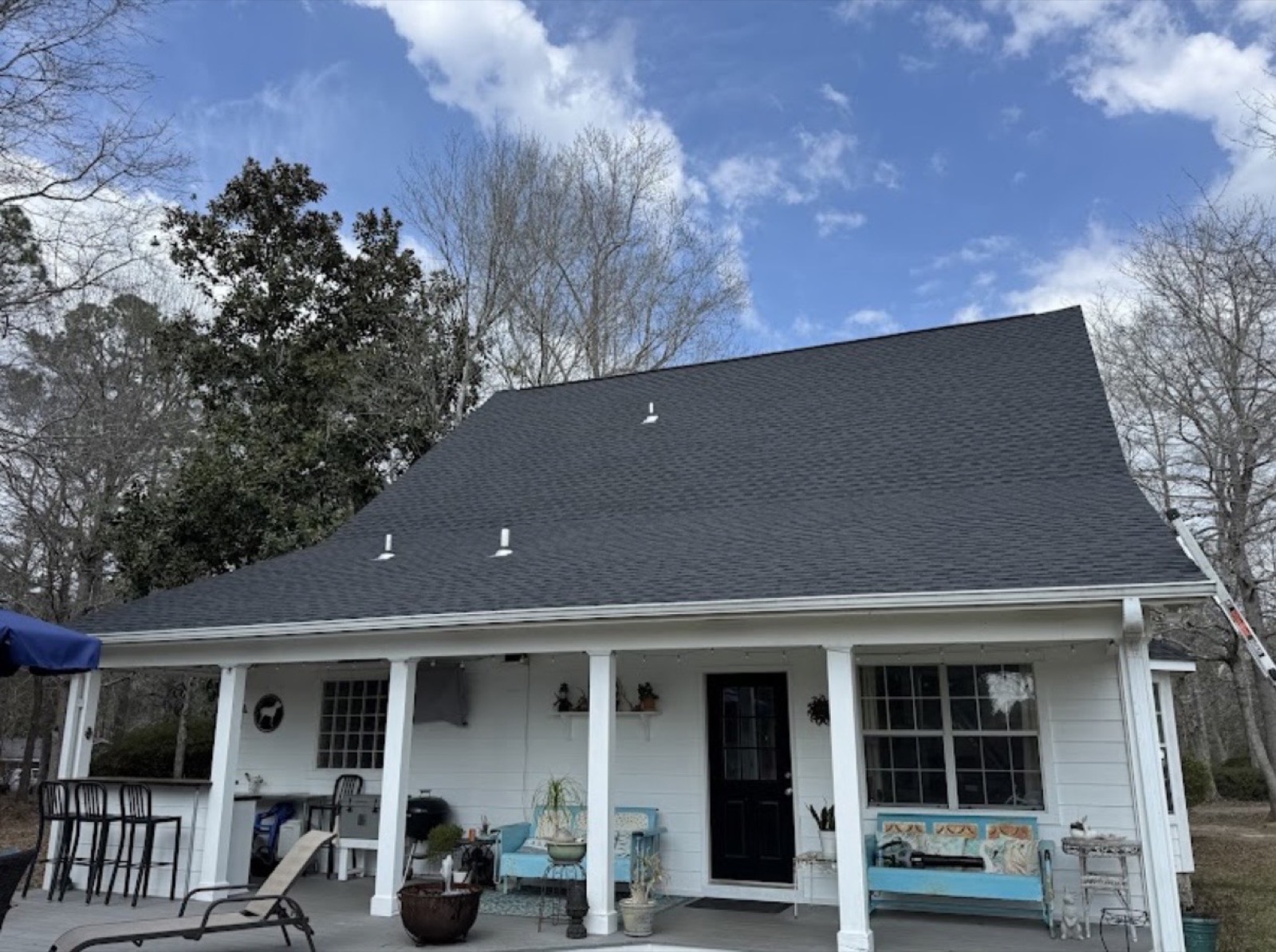 Home with a finished shingle roof and covered front porch
